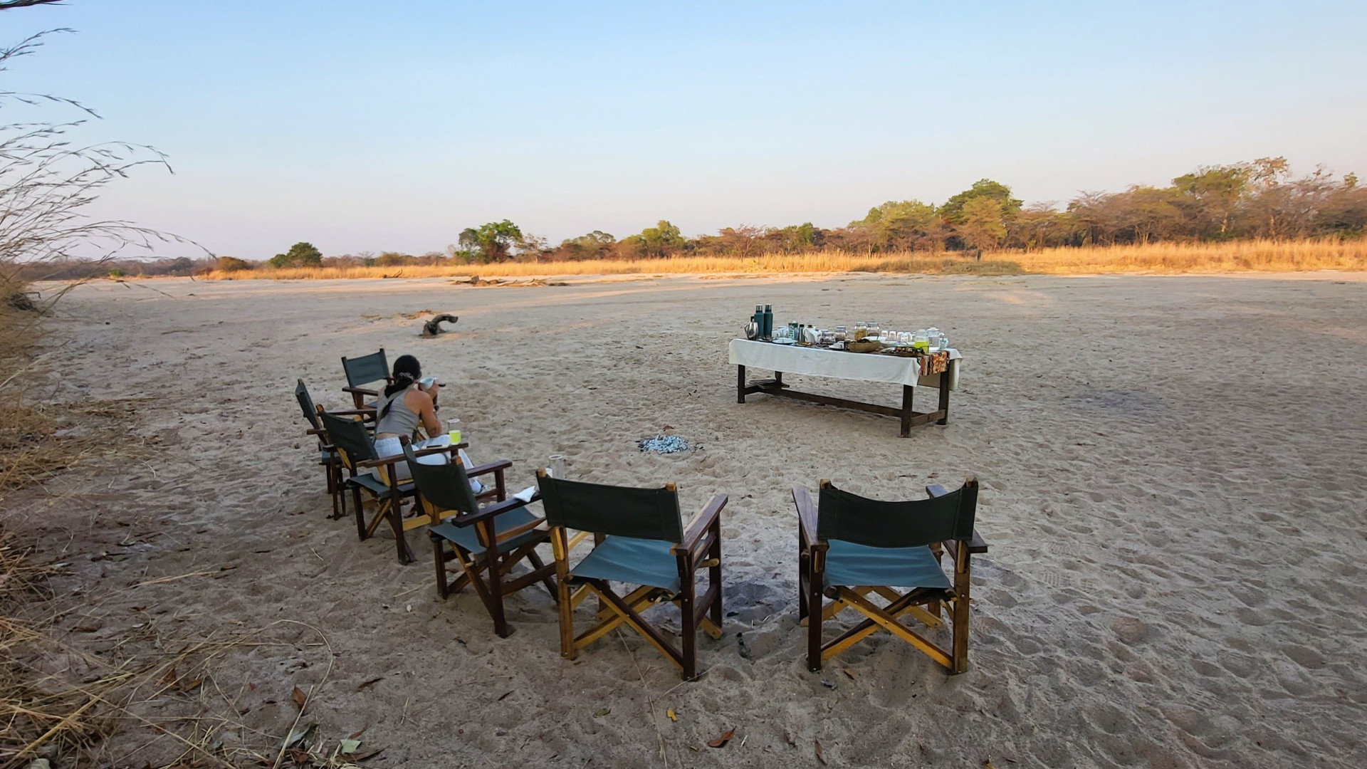 Woman having buffet breakfast in the riverbed watching sunrise